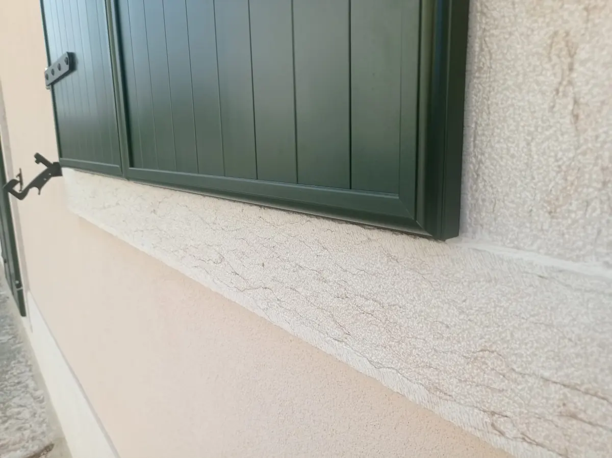 Scuro in alluminio verde fissato alla facciata