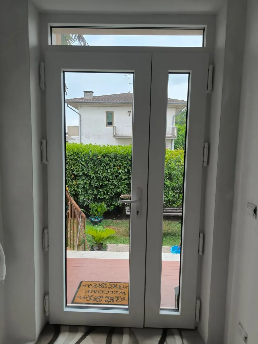 Portafinestra in PVC bianca aperta verso il giardino
