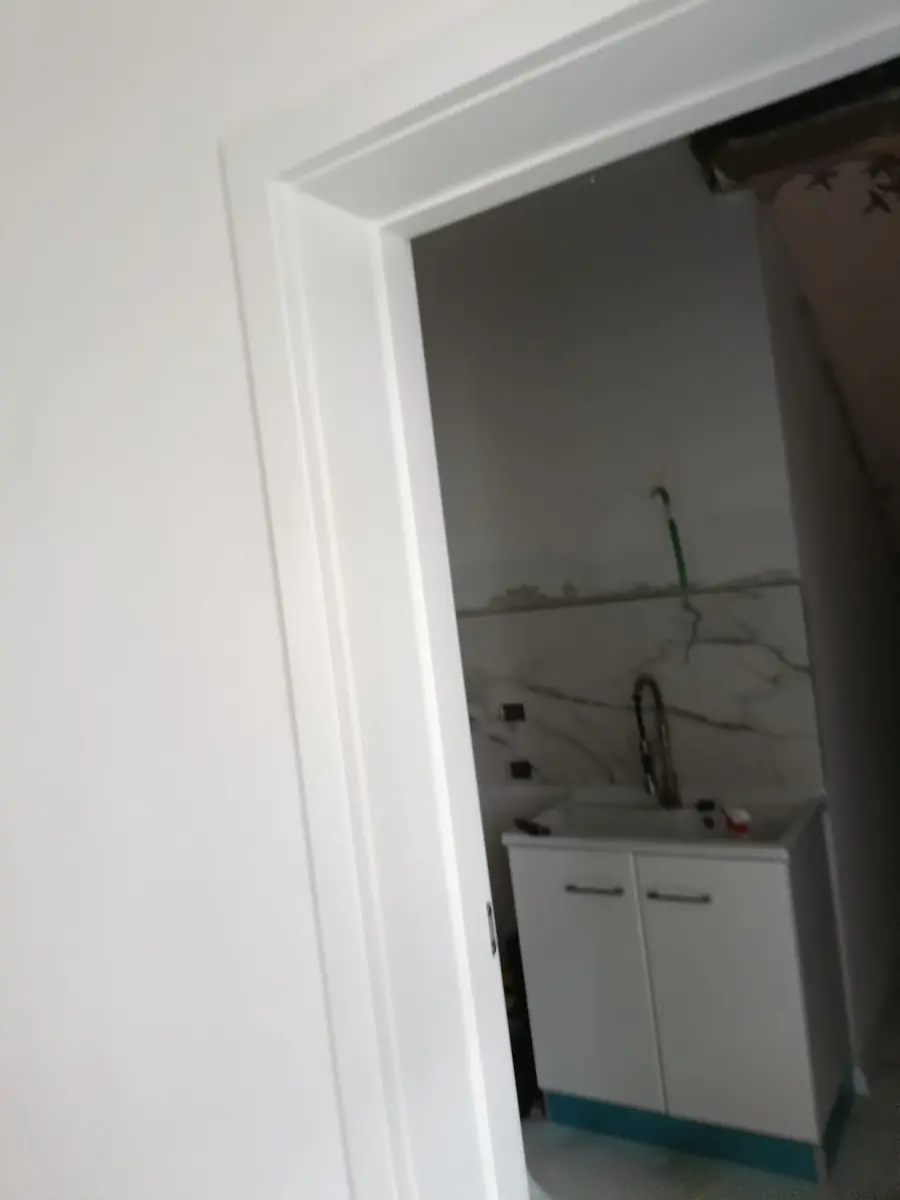 Porta interna aperta su una cucina in ristrutturazione
